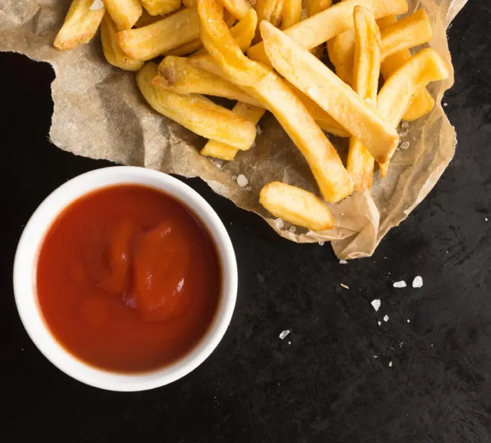 Bovenaanzicht van gezouten frietjes met ketchup